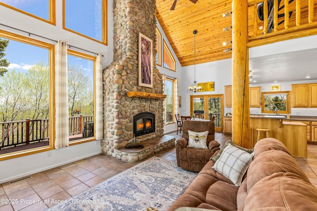 180 Ridge Rd, Gunnison, CO 81230 - living room featuring high vaulted ceiling, baseboards, light tile patterned flooring, a stone fireplace, and wooden ceiling