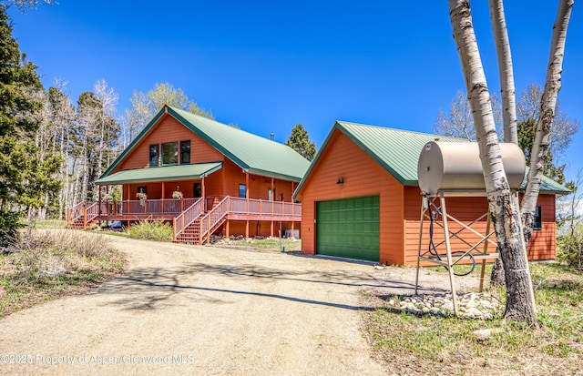 180 Ridge Rd, Gunnison, CO 81230 - rustic home featuring a porch, an outdoor structure, metal roof, and driveway