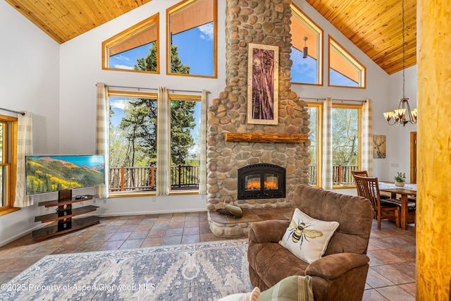 180 Ridge Rd, Gunnison, CO 81230 - living area with high vaulted ceiling, wood ceiling, a chandelier, a stone fireplace, and baseboards