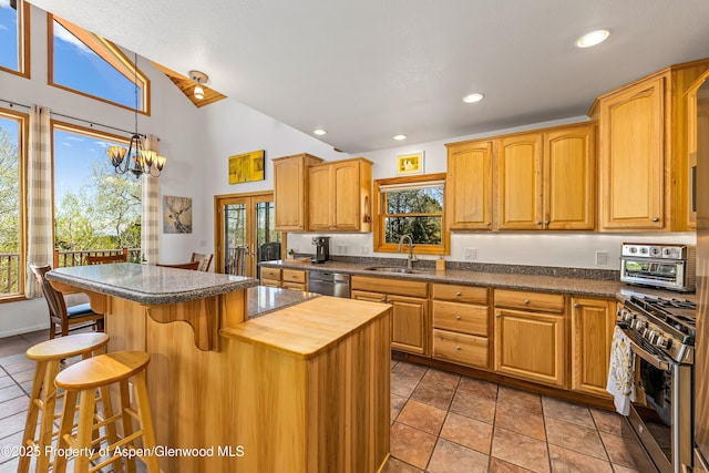 180 Ridge Rd, Gunnison, CO 81230 - kitchen with a sink, appliances with stainless steel finishes, a kitchen breakfast bar, high vaulted ceiling, and hanging light fixtures