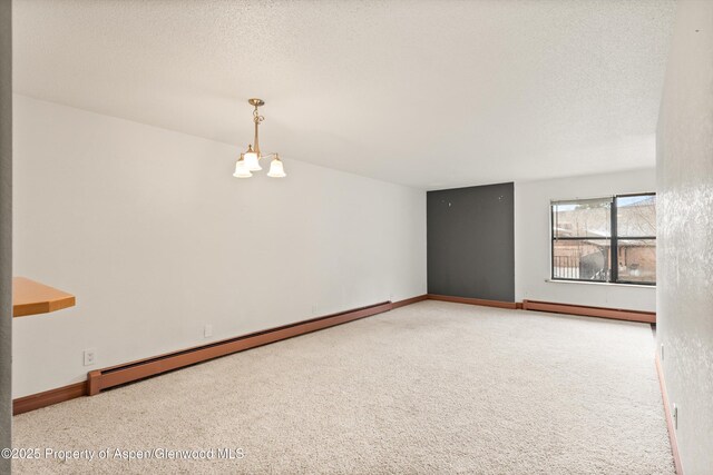 1527 Blake Ave Unit 209, Glenwood Springs, CO 81602 - spare room with a baseboard heating unit, a chandelier, carpet flooring, and a textured ceiling