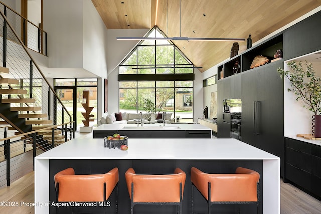 810 W Smuggler St, Aspen, CO 81611 - kitchen with wood ceiling, light wood-type flooring, high vaulted ceiling, a sink, and a kitchen island