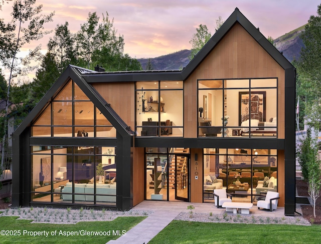 810 W Smuggler St, Aspen, CO 81611 - back of house at dusk with an outdoor hangout area, a patio, and a mountain view