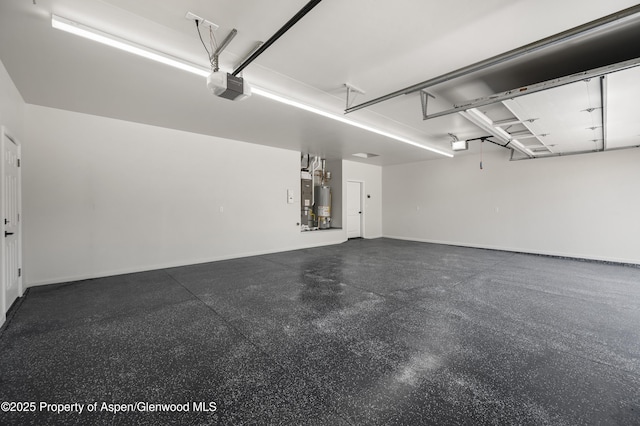 964 E 17th St, Rifle, CO 81650 - garage featuring a garage door opener, baseboards, and water heater