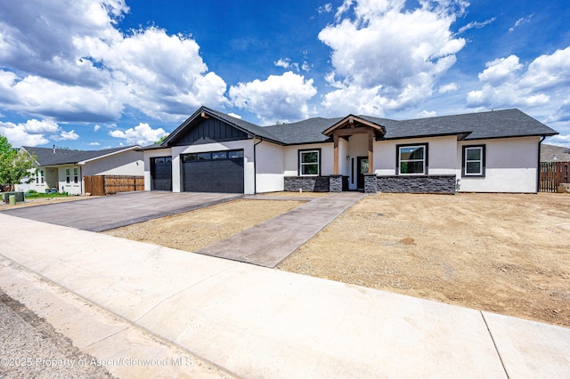 964 E 17th St, Rifle, CO 81650 - view of front of home with stucco siding, driveway, a garage, stone siding, and board and batten siding