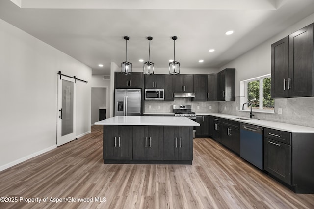 964 E 17th St, Rifle, CO 81650 - kitchen with stainless steel appliances, a sink, under cabinet range hood, light wood-type flooring, and tasteful backsplash