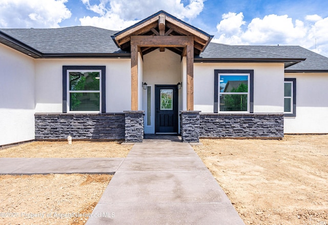 964 E 17th St, Rifle, CO 81650 - view of front facade with stucco siding, a shingled roof, and stone siding