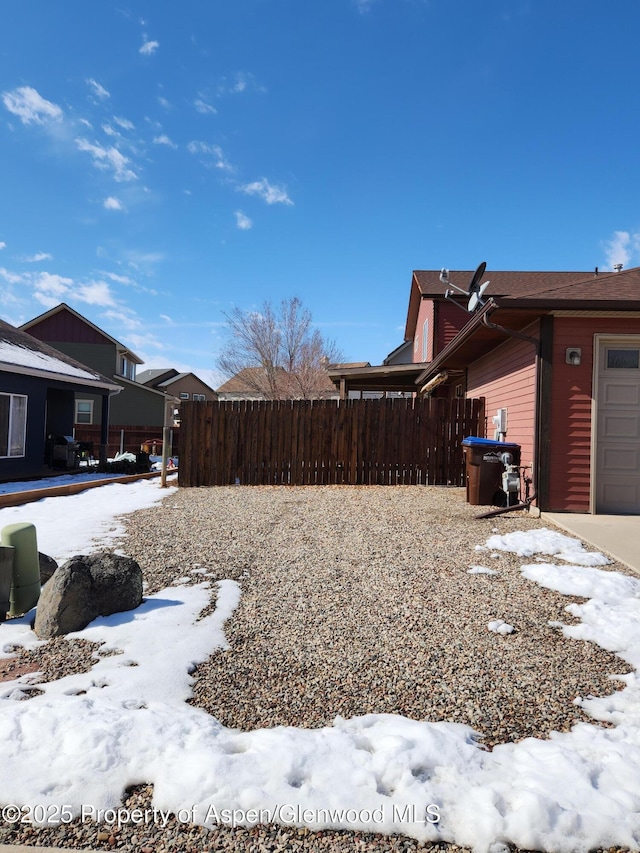 yard covered in snow featuring a garage