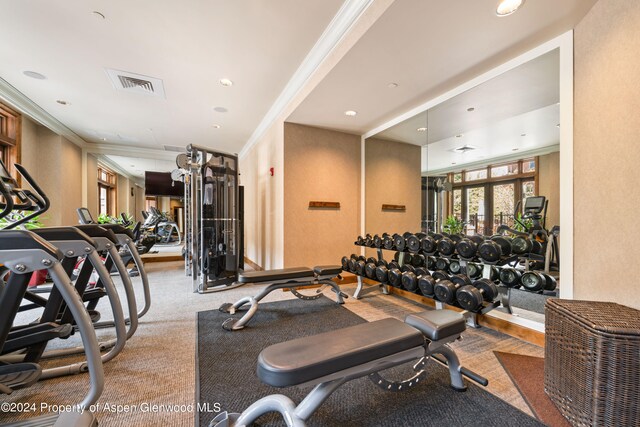 workout area featuring crown molding