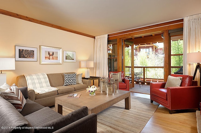 living room featuring ornamental molding and light wood-type flooring