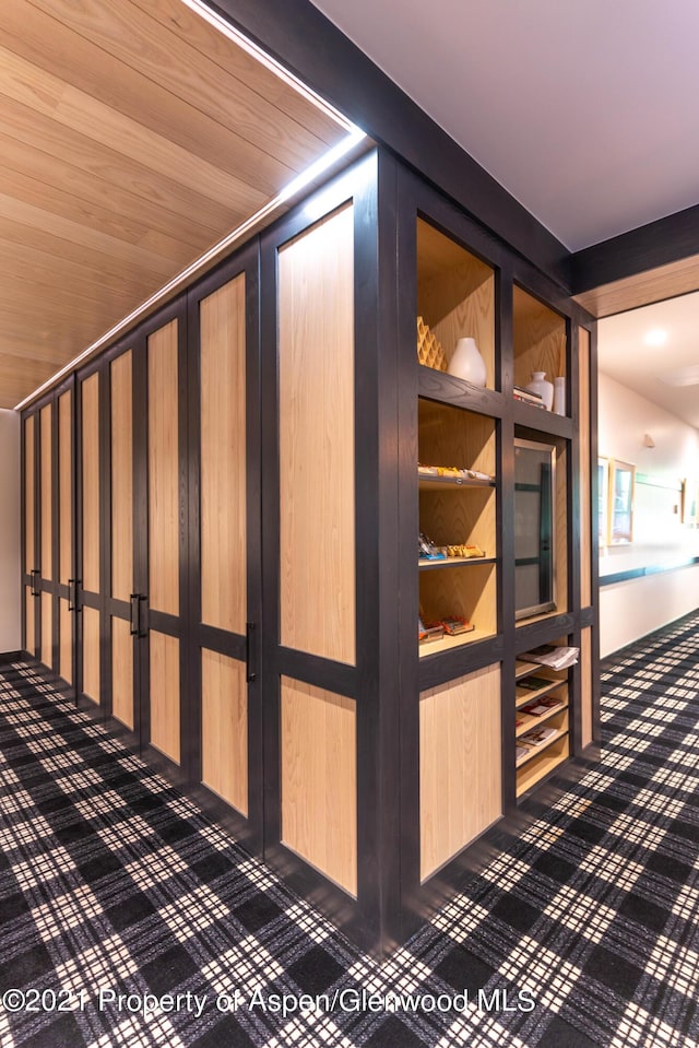 hallway with wood walls and wooden ceiling