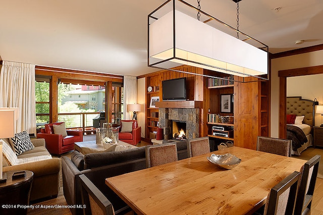 dining room featuring a fireplace and wooden walls