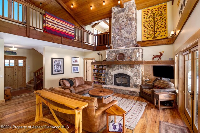 living room with wooden ceiling, high vaulted ceiling, hardwood / wood-style flooring, a fireplace, and plenty of natural light