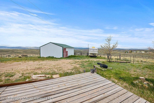 194 Hill Dr, Craig, CO 81625 - wooden terrace featuring an outbuilding, an outdoor structure, fence, and a rural view