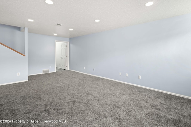 unfurnished room with carpet and a textured ceiling