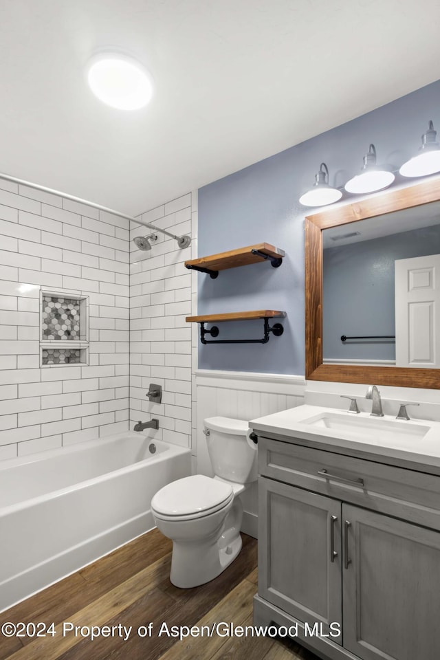 full bathroom with vanity, hardwood / wood-style flooring, toilet, and tiled shower / bath