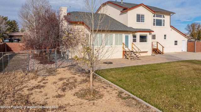 rear view of property with a lawn and a patio