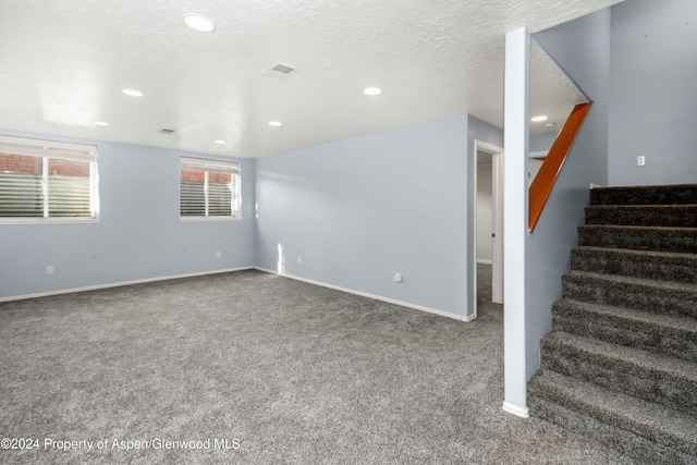 interior space featuring carpet and a textured ceiling