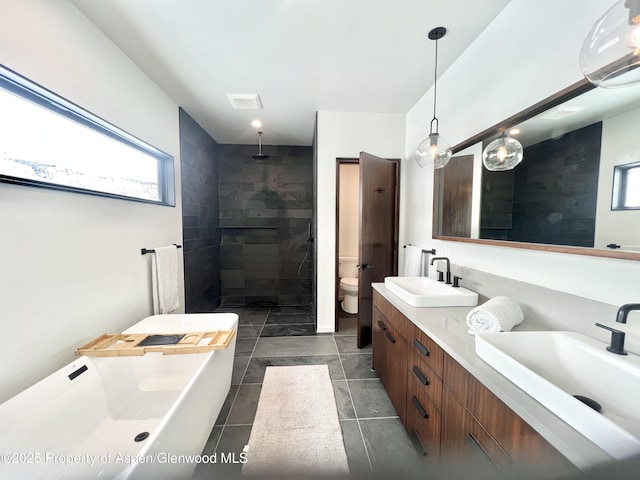 bathroom with a tile shower, vanity, tile patterned flooring, and toilet