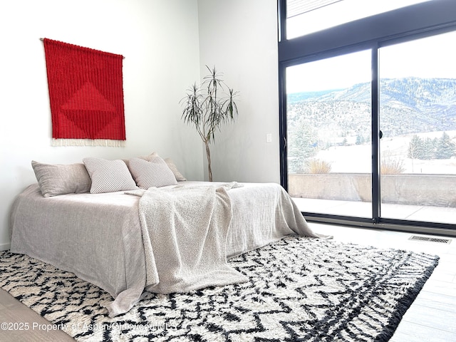 bedroom featuring wood-type flooring and access to exterior