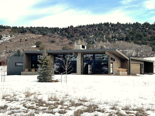 snow covered property with a garage