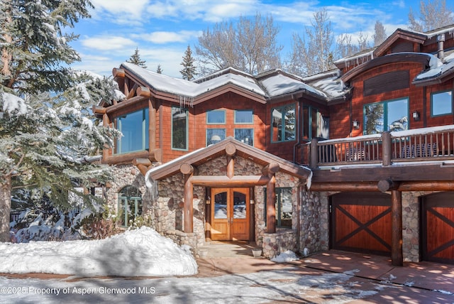 view of front of property with stone siding, driveway, and an attached garage