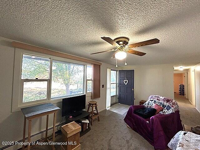 204 W 12th St, Craig, CO 81625 - carpeted living area featuring ceiling fan, a textured ceiling, and a baseboard radiator