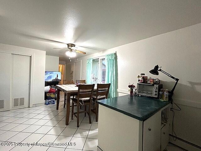 204 W 12th St, Craig, CO 81625 - dining space featuring a ceiling fan, light tile patterned flooring, and a baseboard radiator