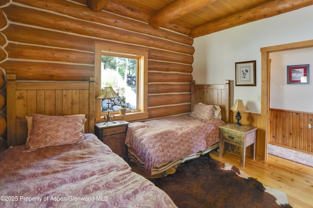 1373 Mclaughlin Ln, Basalt, CO 81621 - bedroom featuring wood finished floors, rustic walls, wainscoting, and wood ceiling with exposed beams