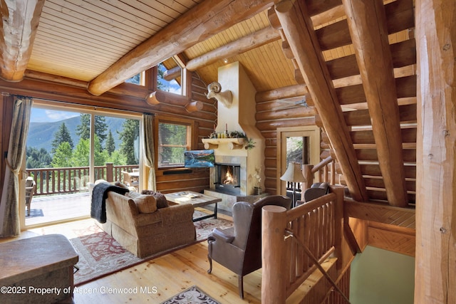 1373 Mclaughlin Ln, Basalt, CO 81621 - living area with rustic walls, wood-type flooring, healthy amount of natural light, wood ceiling, and a lit fireplace