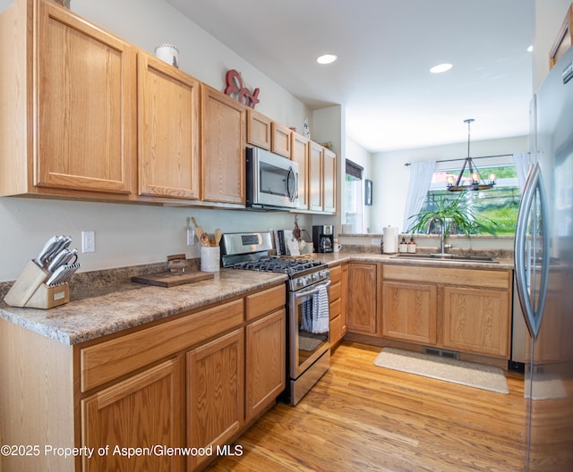 41 Red Cloud Ct, New Castle, CO 81647 - kitchen with appliances with stainless steel finishes, a sink, light wood-type flooring, recessed lighting, and a chandelier