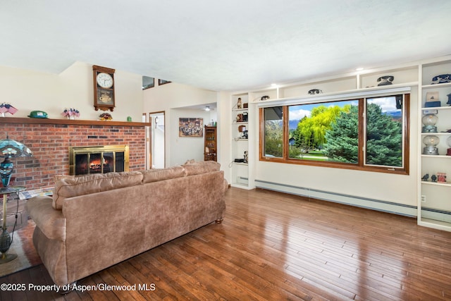 living area with a brick fireplace, baseboard heating, built in features, and wood-type flooring