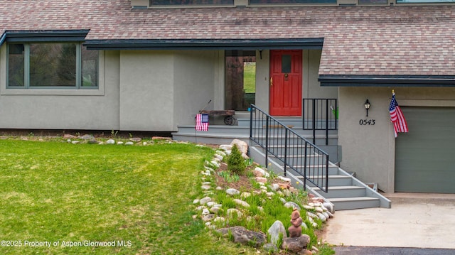 doorway to property featuring a yard, stucco siding, and roof with shingles
