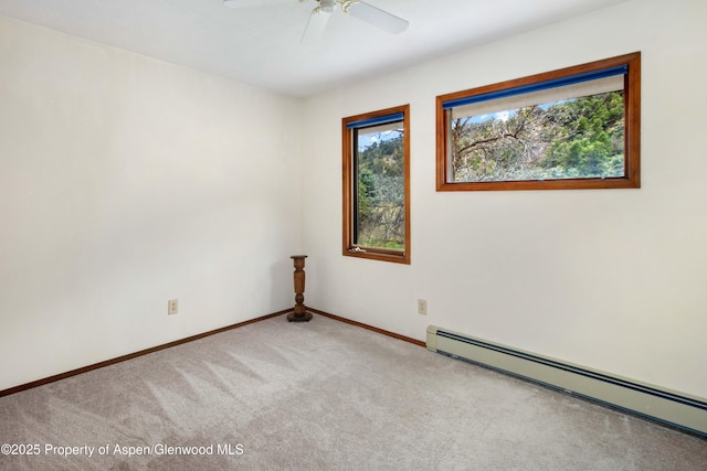 carpeted empty room featuring baseboards, a ceiling fan, and a baseboard radiator
