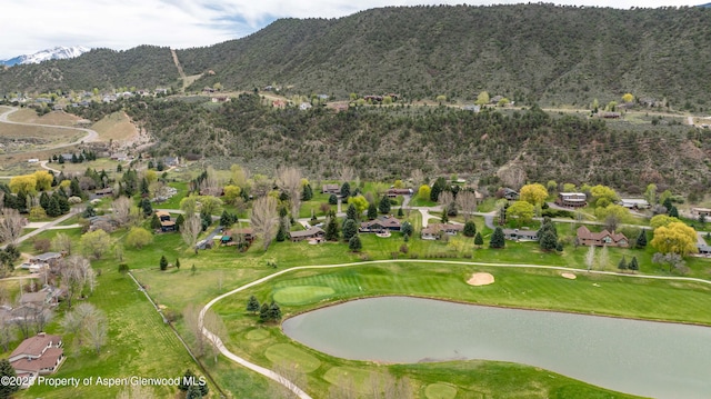 drone / aerial view featuring a residential view, golf course view, and a water and mountain view