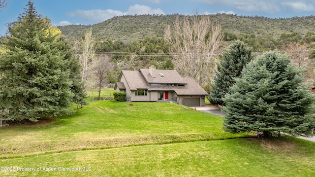 drone / aerial view featuring a wooded view and a mountain view