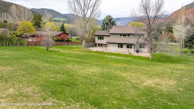 view of yard with fence, a patio area, and a mountain view