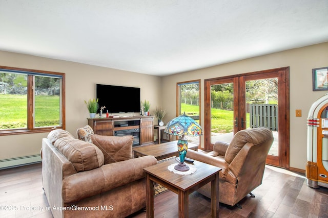 living room with a wealth of natural light, french doors, wood finished floors, and baseboard heating
