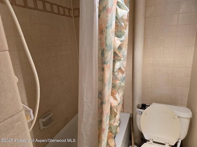 bathroom featuring toilet and shower / tub combo