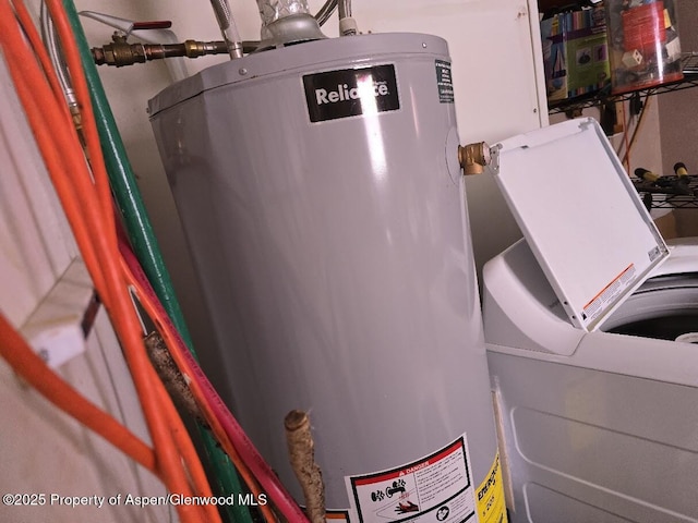 clothes washing area with washer / dryer and water heater