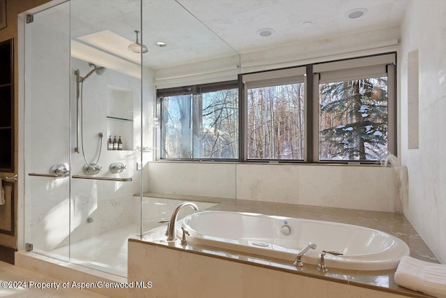 bathroom featuring separate shower and tub