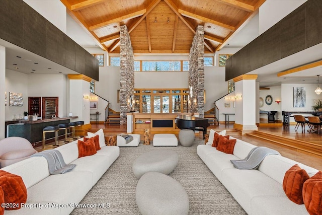 living room with beamed ceiling, hardwood / wood-style floors, high vaulted ceiling, and wooden ceiling