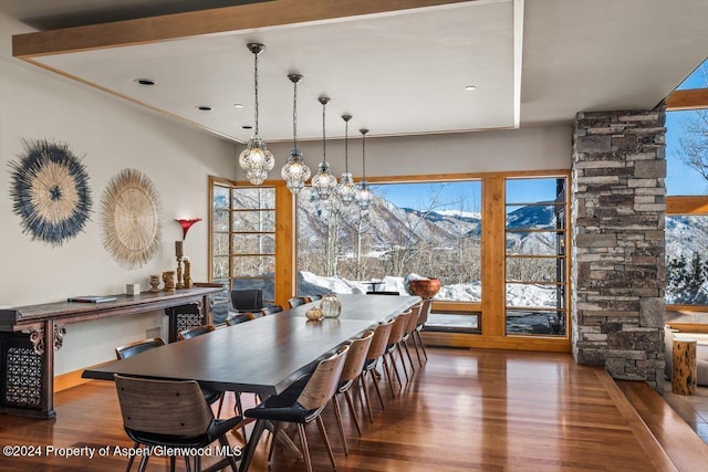 dining room with a mountain view, beam ceiling, and dark hardwood / wood-style floors