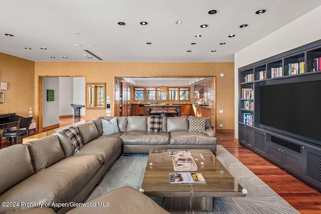 living room with hardwood / wood-style floors and built in shelves