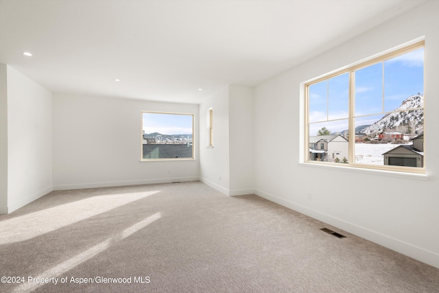 carpeted spare room featuring a mountain view