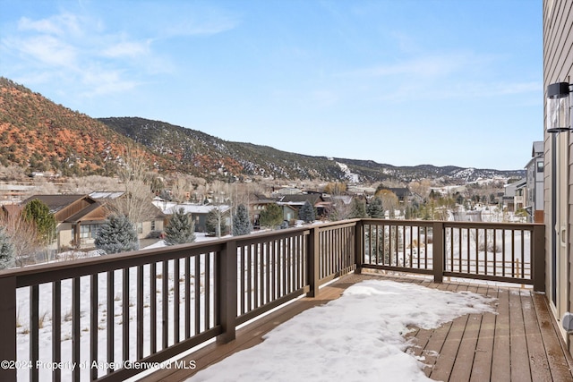 snow covered deck with a mountain view