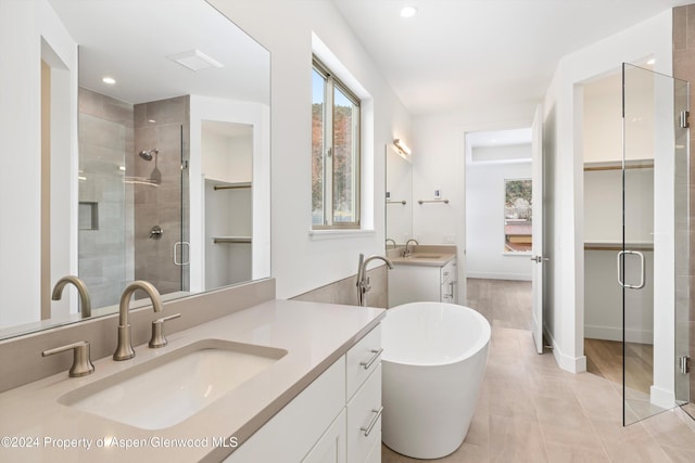 bathroom featuring vanity and independent shower and bath