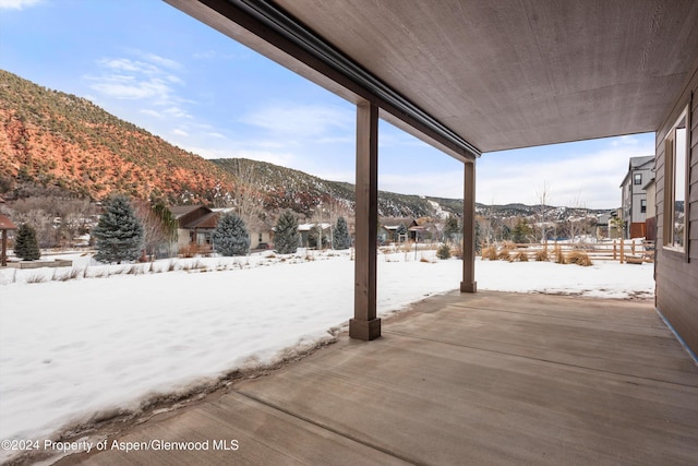 snow covered patio with a mountain view