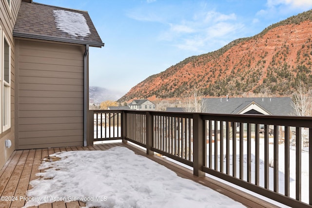 snow covered deck with a mountain view