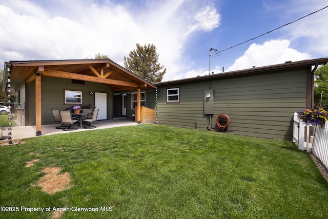 back of house featuring a patio and a lawn